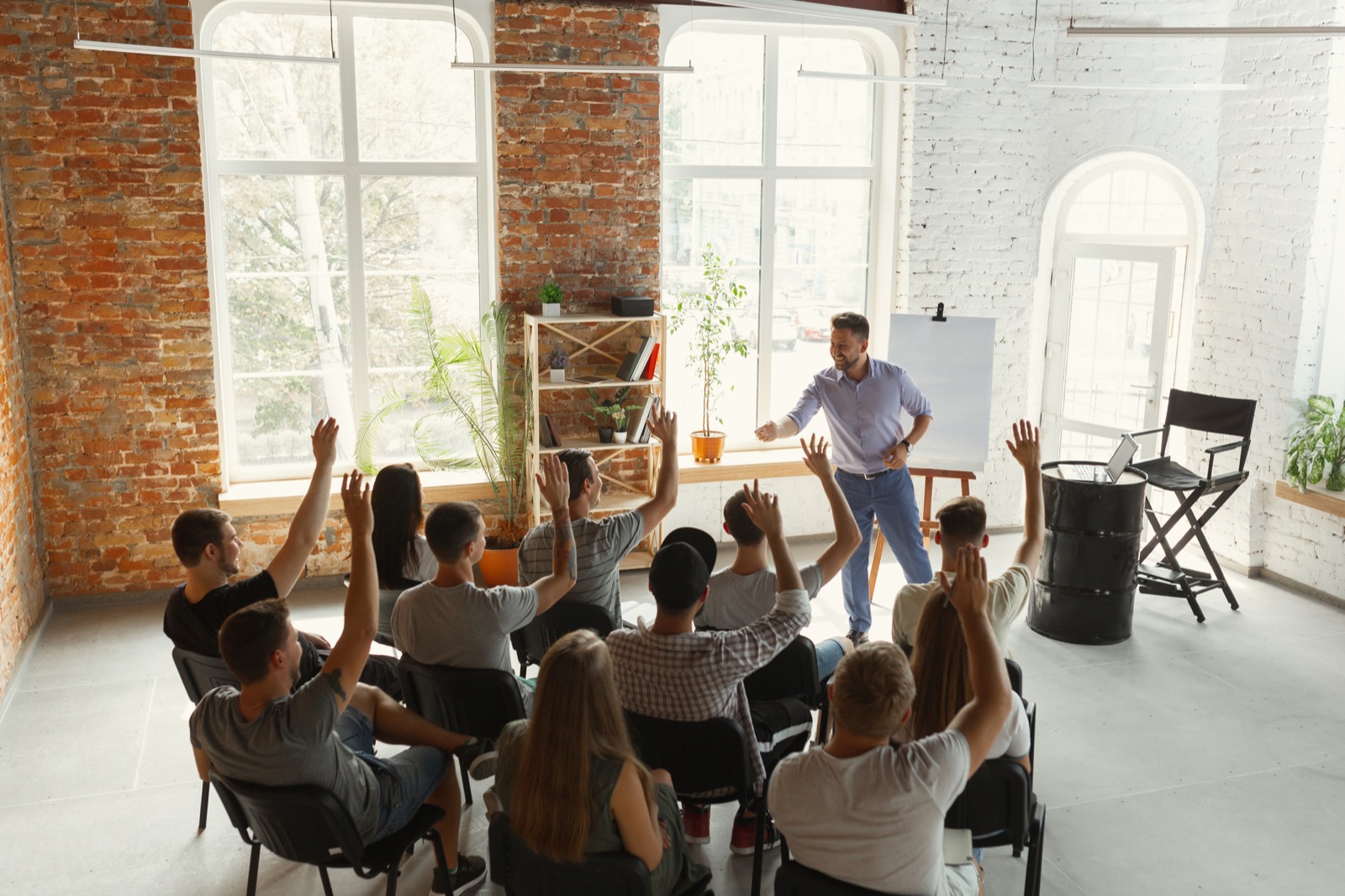 Engaged participants raising hands during a language training seminar