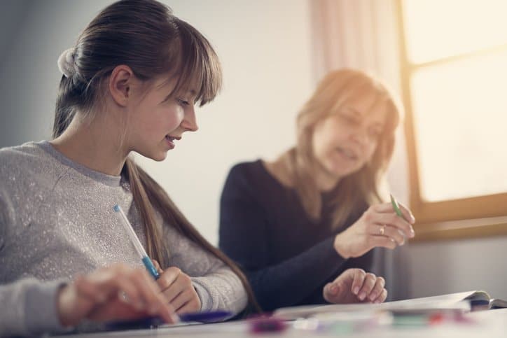 English courses for children in Spain - teacher with student doing classwork